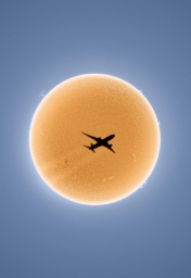 Транзит самолёта по диску Солнца, снятый фотографом Эндрю МакКарти. Рейс United Airlines UA 425 из Сан-Франциско