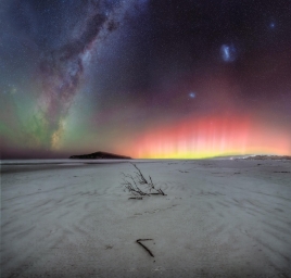 Свежий снимок Млечного Пути, Магеллановых Облаков и Полярного сияния над пляжем Тайери-Мут в Новой Зеландии