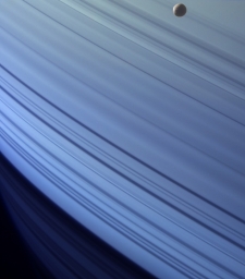 Ледяной спутник Сатурна Мимас на фоне своей планеты