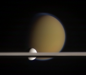 Спутники Сатурна Титан и Тефия, запечатленные зондом Кассини позади колец планеты.