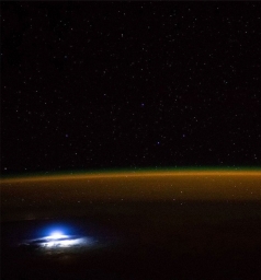 Звезды, свечение атмосферы Земли и вспышка молнии, вид с МКС